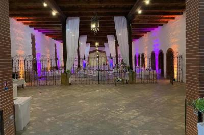 Église en pierre avec une tour, entourée de végétation et éclairée par une lumière naturelle sous un ciel bleu.