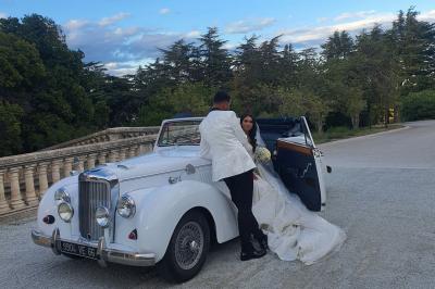 Église en pierre avec une tour, entourée de végétation et éclairée par une lumière naturelle sous un ciel bleu.