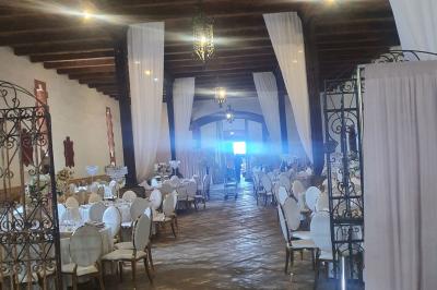 Église en pierre avec une tour, entourée de végétation et éclairée par une lumière naturelle sous un ciel bleu.
