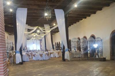Église en pierre avec une tour, entourée de végétation et éclairée par une lumière naturelle sous un ciel bleu.