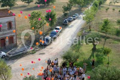 Église en pierre avec une tour, entourée de végétation et éclairée par une lumière naturelle sous un ciel bleu.