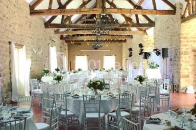 Une mariée en robe blanche applaudit devant un groupe de personnes dans un jardin lors d'une célébration.