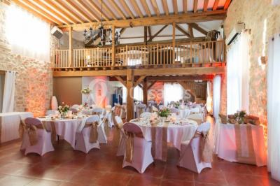 Une mariée en robe blanche applaudit devant un groupe de personnes dans un jardin lors d'une célébration.
