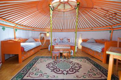 Une mariée en robe blanche applaudit devant un groupe de personnes dans un jardin lors d'une célébration.