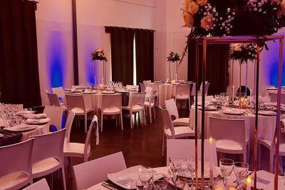 Une mariée en robe blanche applaudit devant un groupe de personnes dans un jardin lors d'une célébration.