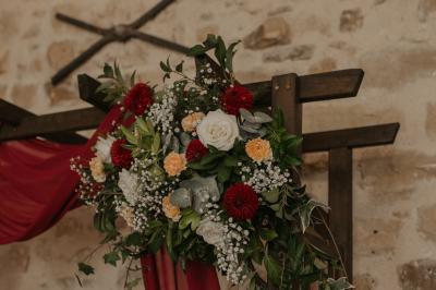 Une mariée en robe blanche applaudit devant un groupe de personnes dans un jardin lors d'une célébration.