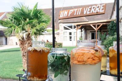 Une mariée en robe blanche applaudit devant un groupe de personnes dans un jardin lors d'une célébration.