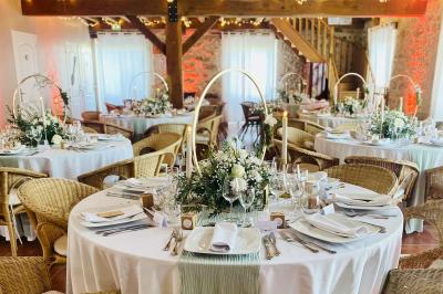 Une mariée en robe blanche applaudit devant un groupe de personnes dans un jardin lors d'une célébration.