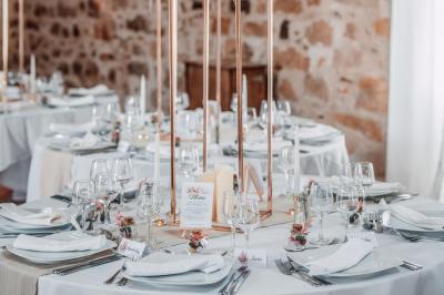 Une mariée en robe blanche applaudit devant un groupe de personnes dans un jardin lors d'une célébration.
