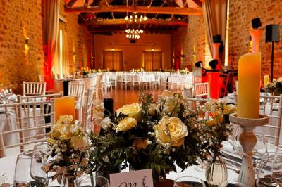 Une mariée en robe blanche applaudit devant un groupe de personnes dans un jardin lors d'une célébration.