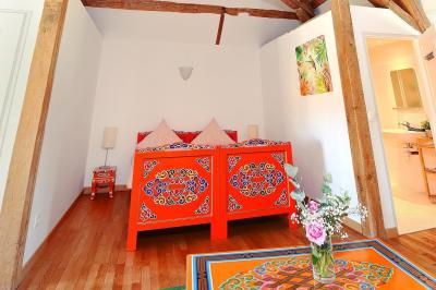 Une mariée en robe blanche applaudit devant un groupe de personnes dans un jardin lors d'une célébration.
