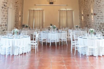 Une mariée en robe blanche applaudit devant un groupe de personnes dans un jardin lors d'une célébration.