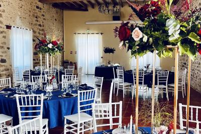 Une mariée en robe blanche applaudit devant un groupe de personnes dans un jardin lors d'une célébration.