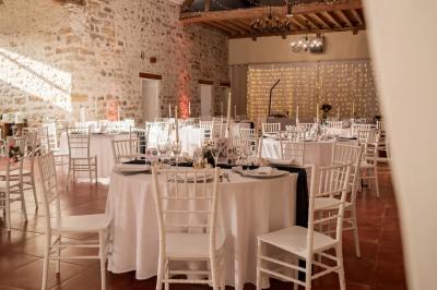Une mariée en robe blanche applaudit devant un groupe de personnes dans un jardin lors d'une célébration.