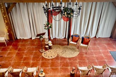 Une mariée en robe blanche applaudit devant un groupe de personnes dans un jardin lors d'une célébration.