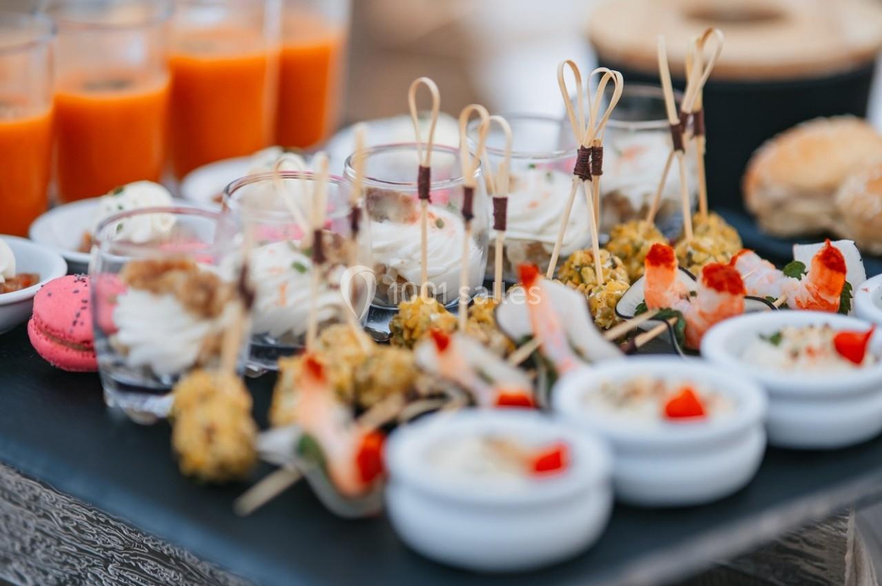 Plateau de verrines, brochettes et amuse-bouches variés présentés sur une table lors d'un buffet.