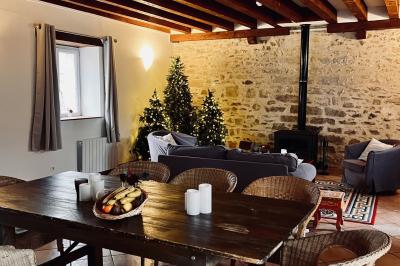 Une mariée en robe blanche applaudit devant un groupe de personnes dans un jardin lors d'une célébration.