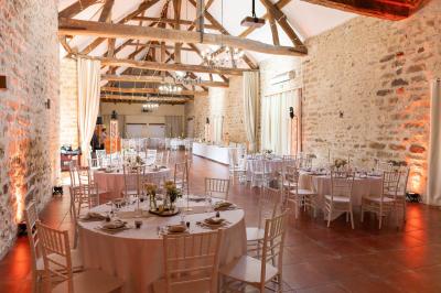 Une mariée en robe blanche applaudit devant un groupe de personnes dans un jardin lors d'une célébration.