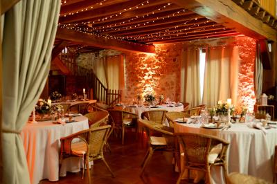 Une mariée en robe blanche applaudit devant un groupe de personnes dans un jardin lors d'une célébration.
