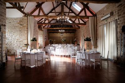 Une mariée en robe blanche applaudit devant un groupe de personnes dans un jardin lors d'une célébration.