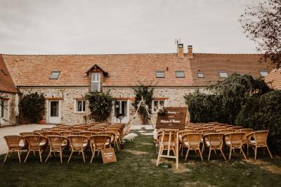 Une mariée en robe blanche applaudit devant un groupe de personnes dans un jardin lors d'une célébration.