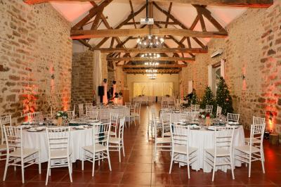 Une mariée en robe blanche applaudit devant un groupe de personnes dans un jardin lors d'une célébration.