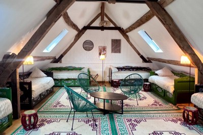 Un couple de mariés entouré de leurs témoins et demoiselles d'honneur posant en extérieur au coucher du soleil.