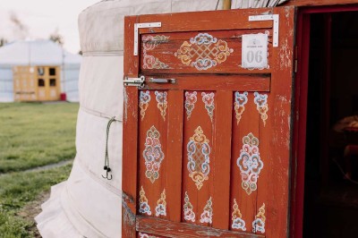 Un couple de mariés entouré de leurs témoins et demoiselles d'honneur posant en extérieur au coucher du soleil.