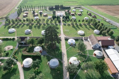 Un couple de mariés entouré de leurs témoins et demoiselles d'honneur posant en extérieur au coucher du soleil.