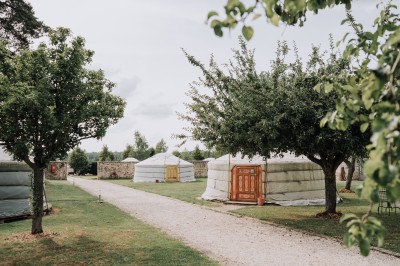 Un couple de mariés entouré de leurs témoins et demoiselles d'honneur posant en extérieur au coucher du soleil.