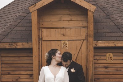 Un couple de mariés entouré de leurs témoins et demoiselles d'honneur posant en extérieur au coucher du soleil.