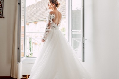 Un couple de mariés entouré de leurs témoins et demoiselles d'honneur posant en extérieur au coucher du soleil.