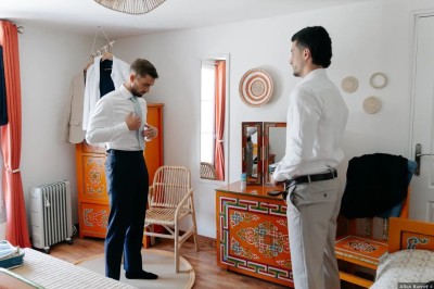 Un couple de mariés entouré de leurs témoins et demoiselles d'honneur posant en extérieur au coucher du soleil.