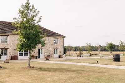 Un couple de mariés entouré de leurs témoins et demoiselles d'honneur posant en extérieur au coucher du soleil.