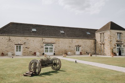 Un couple de mariés entouré de leurs témoins et demoiselles d'honneur posant en extérieur au coucher du soleil.