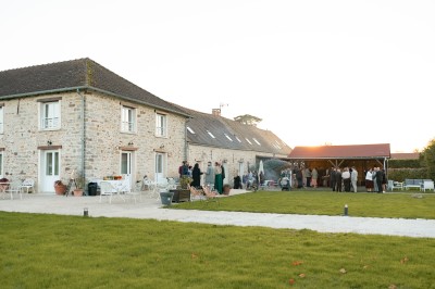 Un couple de mariés entouré de leurs témoins et demoiselles d'honneur posant en extérieur au coucher du soleil.