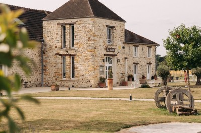Un couple de mariés entouré de leurs témoins et demoiselles d'honneur posant en extérieur au coucher du soleil.