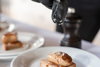 Un couple de mariés entouré de leurs témoins et demoiselles d'honneur posant en extérieur au coucher du soleil.