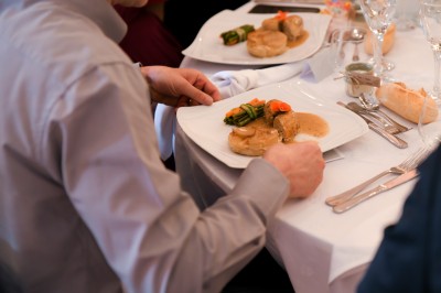 Un couple de mariés entouré de leurs témoins et demoiselles d'honneur posant en extérieur au coucher du soleil.