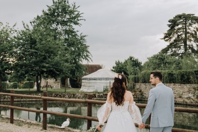Un couple de mariés entouré de leurs témoins et demoiselles d'honneur posant en extérieur au coucher du soleil.