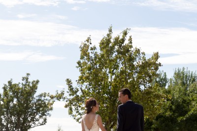 Un couple de mariés entouré de leurs témoins et demoiselles d'honneur posant en extérieur au coucher du soleil.