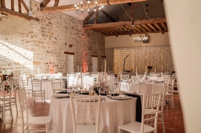 Un couple de mariés entouré de leurs témoins et demoiselles d'honneur posant en extérieur au coucher du soleil.