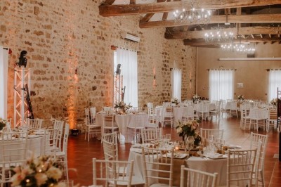 Un couple de mariés entouré de leurs témoins et demoiselles d'honneur posant en extérieur au coucher du soleil.