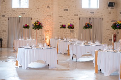 Un couple de mariés entouré de leurs témoins et demoiselles d'honneur posant en extérieur au coucher du soleil.