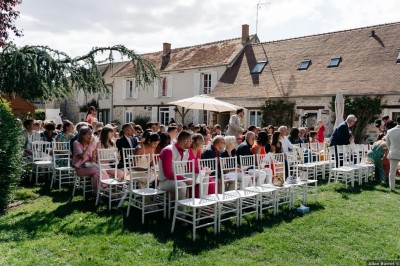 Un couple de mariés entouré de leurs témoins et demoiselles d'honneur posant en extérieur au coucher du soleil.