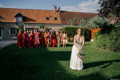 Un couple de mariés entouré de leurs témoins et demoiselles d'honneur posant en extérieur au coucher du soleil.
