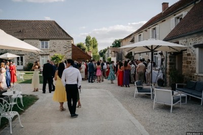 Un couple de mariés entouré de leurs témoins et demoiselles d'honneur posant en extérieur au coucher du soleil.
