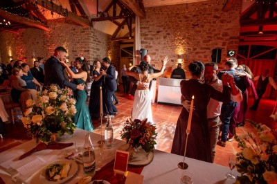 Un couple de mariés entouré de leurs témoins et demoiselles d'honneur posant en extérieur au coucher du soleil.