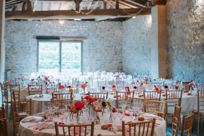 Miniature Location salle Beaujeu (Rhône) - Le Domaine de Vavril #6 Salle voûtée en pierre avec un sol en béton poli, éclairée par des lumières chaudes, et un vase de fleurs au centre.