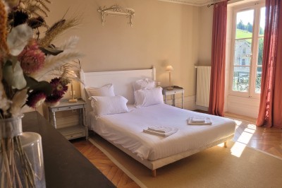 Miniature Location salle Beaujeu (Rhône) - Le Domaine de Vavril #16 Salle voûtée en pierre avec un sol en béton poli, éclairée par des lumières chaudes, et un vase de fleurs au centre.